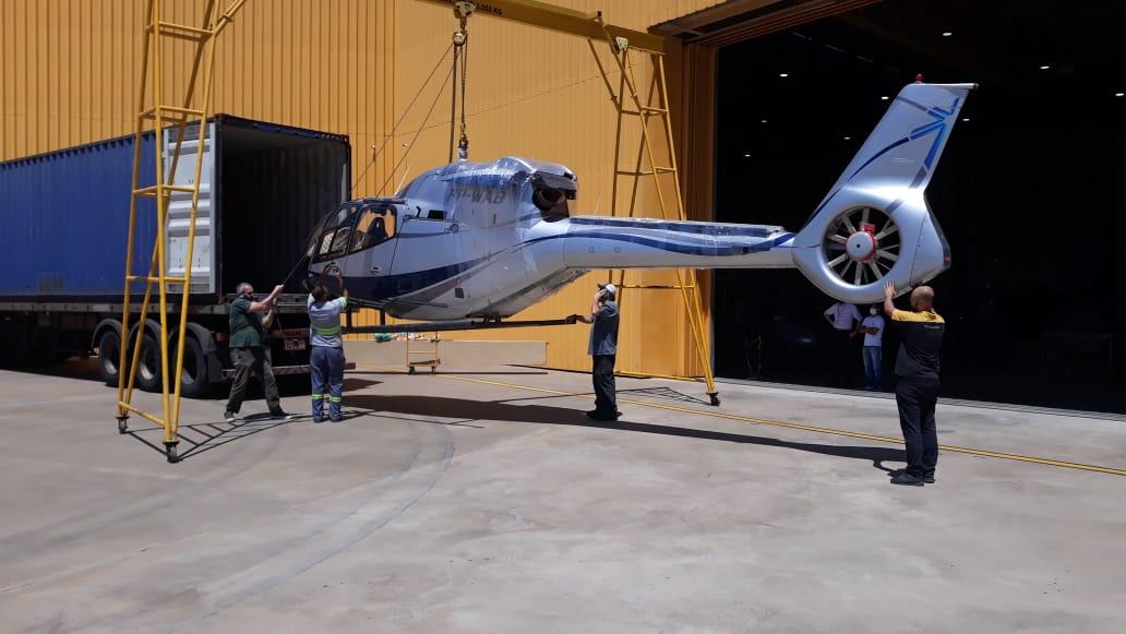 Helicóptero sendo embarcado em container para transporte porta a porta